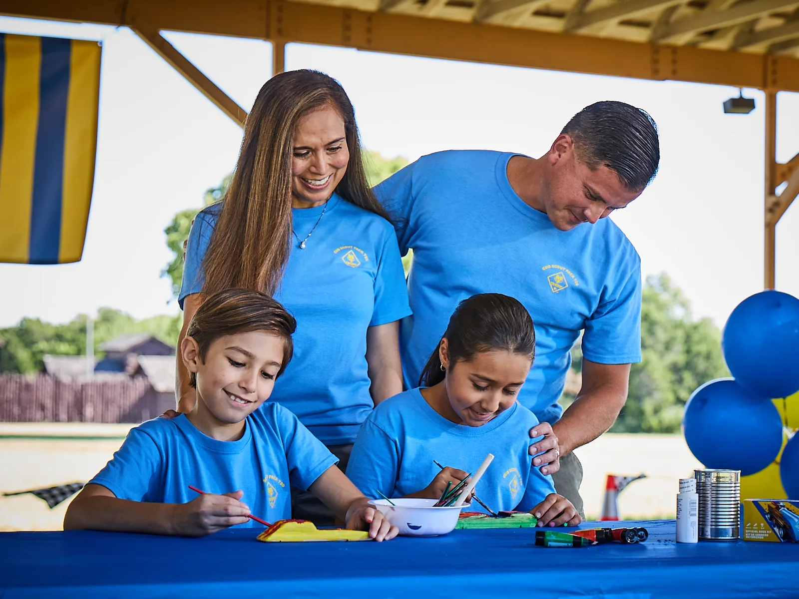 Cub Scout families around a table decorated in blue and gold