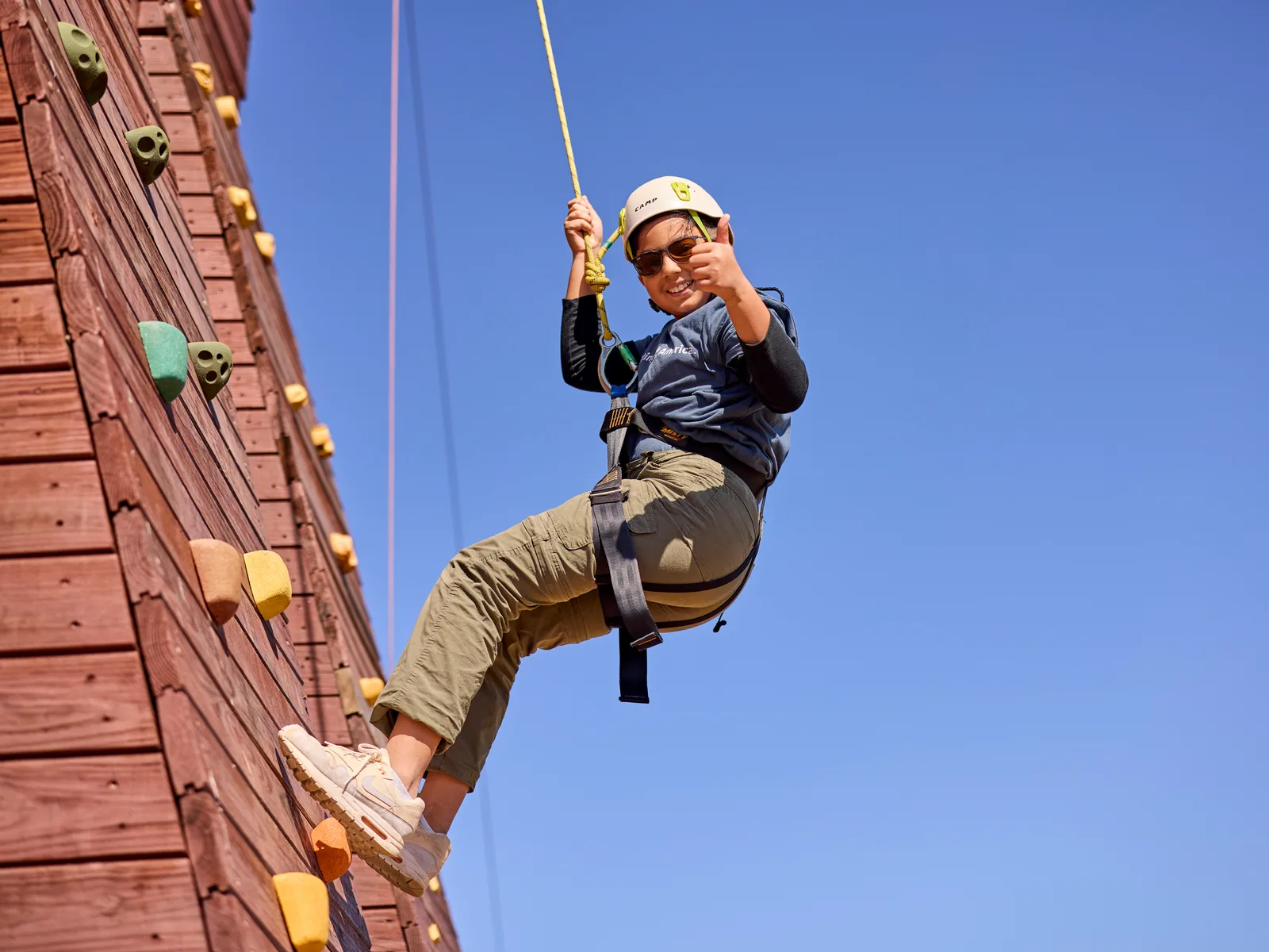 A Cub Scout roped up and climbing a wall at Triangle Rock Club