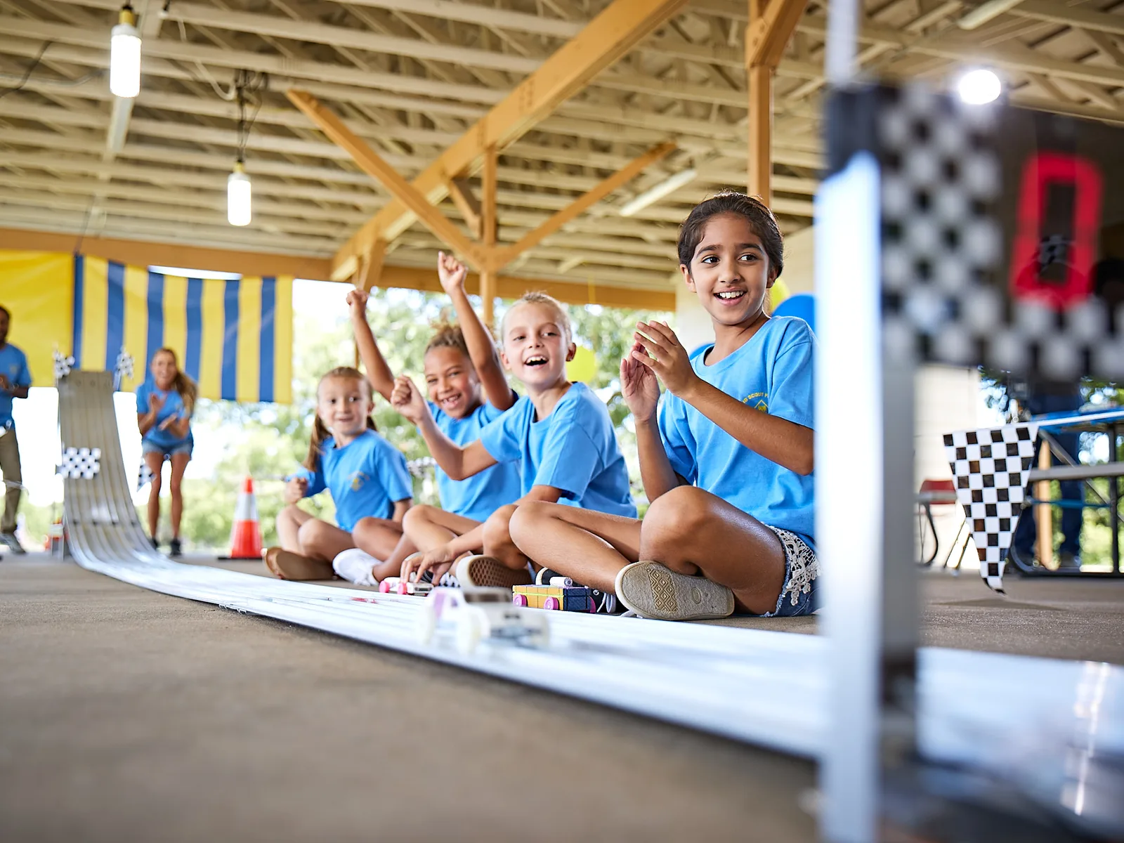 Cub Scouts cheering as Pinewood Derby cars race down the track