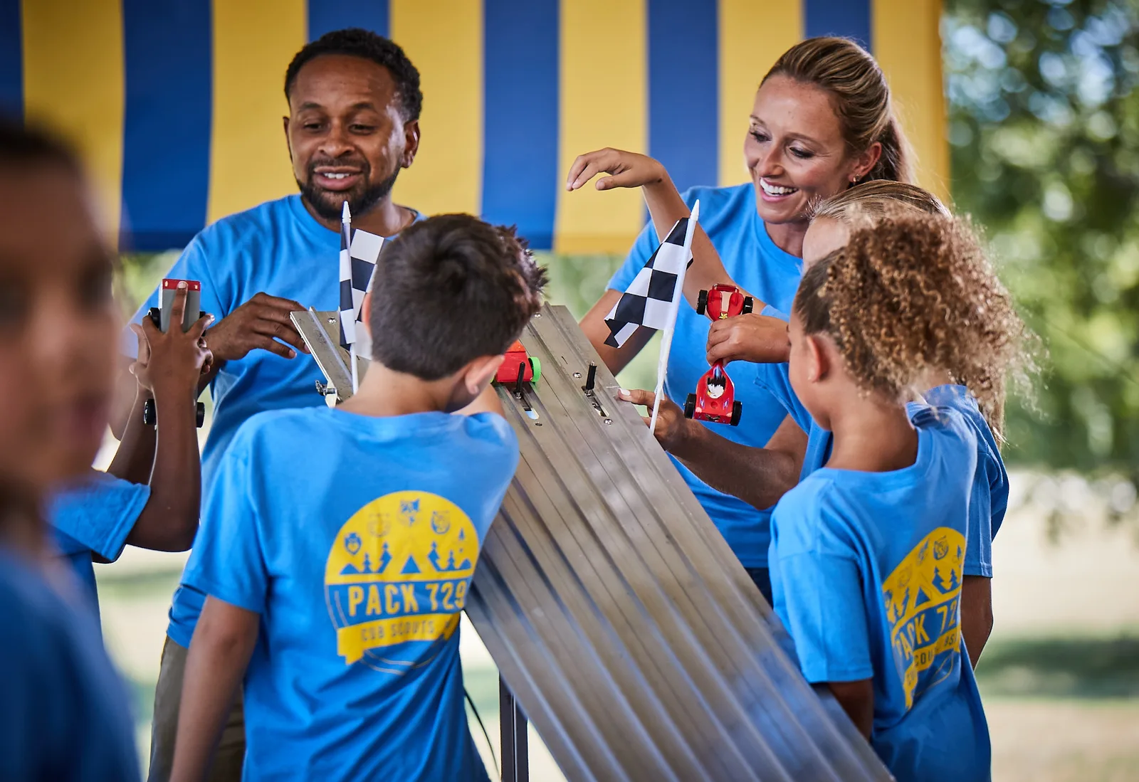 Scouts and parents crowded around the finish line of a Pinewood Derby track