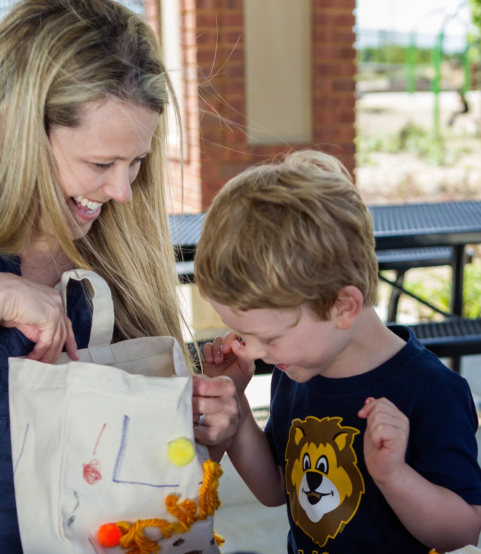 An adult helping a young Lion Scout with a craft project